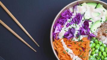 Rotating top view of Poke Bowl with Shrimps and chopsticks on Black Background video