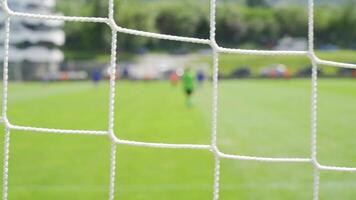 professional soccer kids match behind the goal net on focus and blurred background for text video