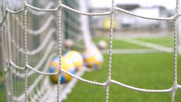 football soccer balls in the net at field blurred net video