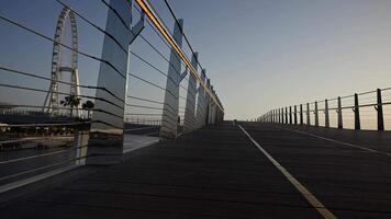 A view of a bridge with a roller coaster in the background at Dubai sunrise video