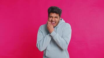 Indian man touching cheek, closing eyes with expression of terrible suffer from painful toothache video