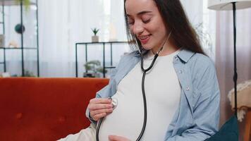 Happy pregnant young woman using stethoscope listening to baby heartbeat unborn child vital signs video