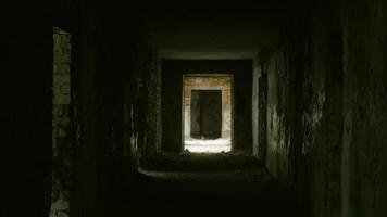 Soft rays of light gradually penetrating dilapidated corridor interior, revealing shadowy architectural details and transforming dark abandoned space with increasing luminosity video