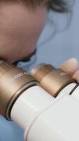 scientifique ajustement microscope, conduite recherche dans une moderne laboratoire. le laboratoire est équipé avec Avancée technologie, reflétant le Coupe bord la nature de sa travail. verticale métrage video