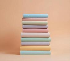 Stack of Pastel-Colored Books Against a Soft Beige Background photo