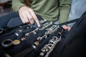 Careful hands clean clarinet with soft cloth, removing traces of use while instrument rests in case photo