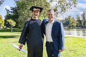 Portrait of a happy caucasian graduated young man with his fathe photo