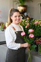 Happy owner with bouquet of flowers in shop photo