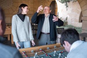 A granddaugther and grandfather are having fun after being scored in table football photo