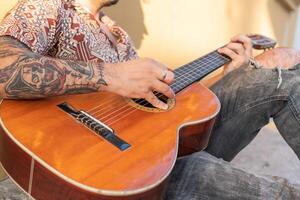 Anonymous street musician playing guitar in the street photo