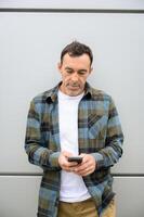 Cheerful man using smartphone in room photo