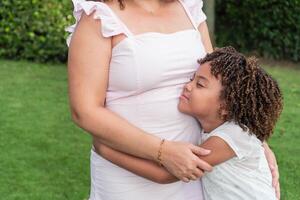 Girl hugging her mother in the open air photo