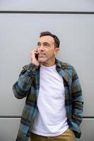Smiling man talking on smartphone and looking away photo