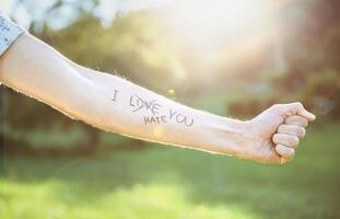 Male arm with text -I hate you- written in skin photo