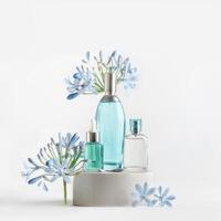 Beauty products in blue glass spray and pipette bottles standing on podium with flowers and petals at white background. Cosmetic setting with serum,perfume fragrance and toner. Front view photo