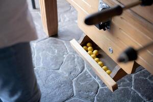 Close up of some yellow table football balls ready to be played in the dispenser photo