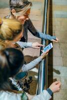 Top view of smiling women runners friends looking training route map on tracker cellphone app. photo