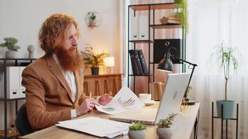 Businessman working on laptop at home office desk talks on online communication webcam call video