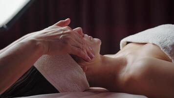 Spa facial massage with client lying on table video