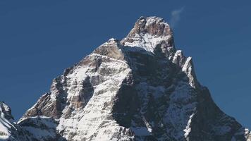 Aerial view of the Matterhorn mountain from the Italian side, showcasing its snow covered peak, rugged features, and gradual motion against a clear sky. video
