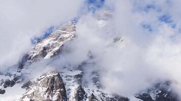Aerial view of Cervino Ski Paradise and Cervino town with the Matterhorn's snow covered peaks partially shrouded in clouds, captured in upward motion. video