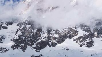 Aerial view of Cervino Ski Paradise and Cervino town, featuring the Matterhorn partially covered by shifting clouds with gradual camera motion. video
