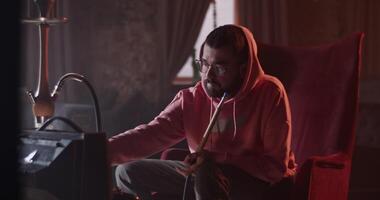 Man pausing videogame and refreshing with drink in hookah bar video