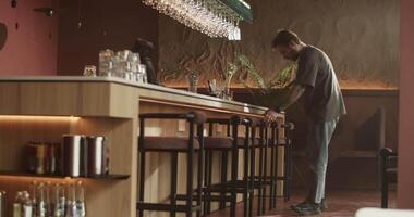 Barman wiping counter while preparing bar for opening video