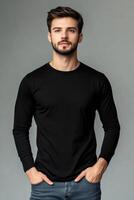 Man in black t - shirt standing in front of gray background photo