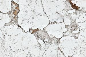 Seamless cracked white plaster with some brown patches, showcasing a distressed and weathered texture. photo