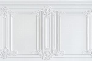Elegant white wall with intricate moldings and decorative elements, featuring empty frames for artwork or mirrors. photo