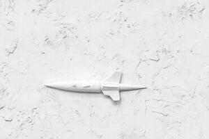 Seamless minimalist white rocket model placed on a textured white background, emphasizing simplicity and modern design. photo
