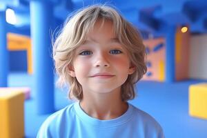 A young boy in a blue shirt standing in front of colorful cubes photo