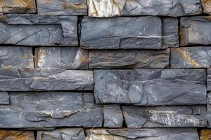 Textured artesia stone cladding wall made of gray slate tiles, showcasing various shades of gray and hints of gold. photo