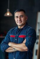 Portrait of a young man in a blue shirt standing in front of a wooden table photo