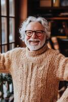 A man with glasses and a sweater standing in front of a window photo