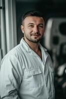 A man in a white shirt standing in front of a car photo