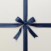 A navy blue ribbon tied in a bow on a light cream background, forming a cross pattern. photo