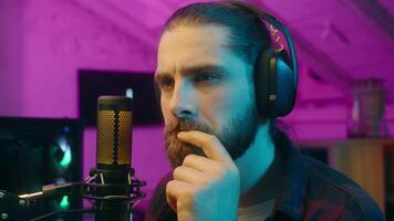Contemplative Caucasian streamer gamer influencer man guy think contemplate host search solution cyber sport game at home addict blogger idea male raising index finger vlogger smile neon realization video