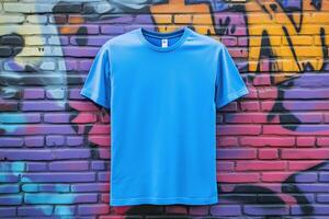 A blue t - shirt is hanging against a wall photo