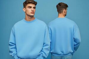 Two men in blue sweatshirts standing in front of a blue wall photo