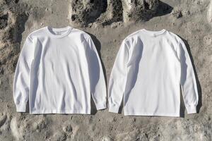 Two white long - sleeved t - shirts on a rock surface photo