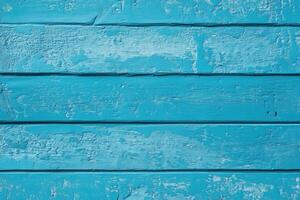 A close-up of a weathered blue wooden wall with visible texture and paint peeling. photo