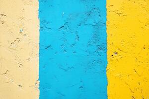 A vibrant wall featuring three vertical stripes in yellow, blue, and light blue. The textured surface adds depth and character to the colors. photo