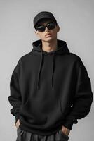 A man in a black hoodie and sunglasses photo