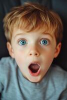 A young boy with his mouth open and a shocked expression photo