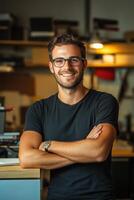 Portrait of a young man with glasses standing in front of a desk in his office photo