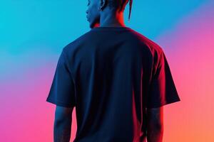 A man in a black t - shirt standing in front of a colorful background photo