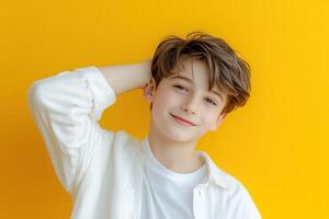 Portrait of a cute boy with his hands on his head on a yellow background photo