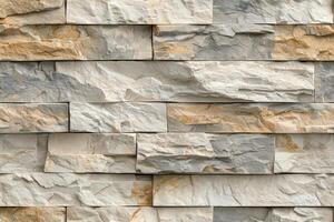 Textured artesia stone cladding wall featuring various shades of gray and beige. The stones are arranged in a staggered pattern, showcasing natural variations in color and texture. photo
